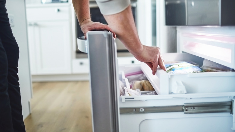 Hand reaching into freezer