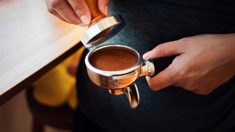 Hand tamping coffee