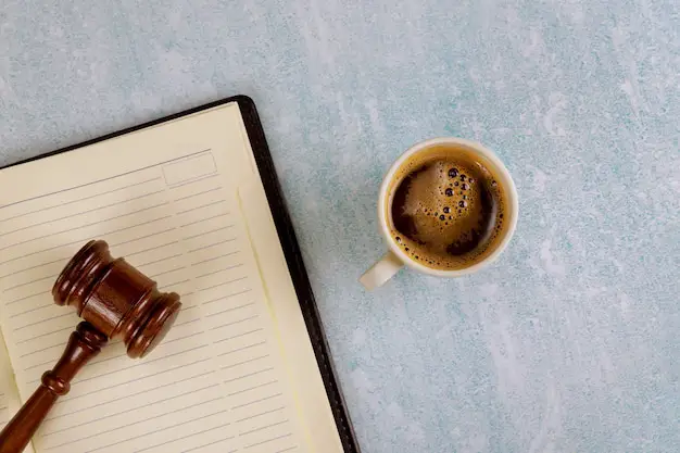 Mesa de escritorio de oficina de justicia legal con suministros, taza de café en un martillo de juez | Foto Premium